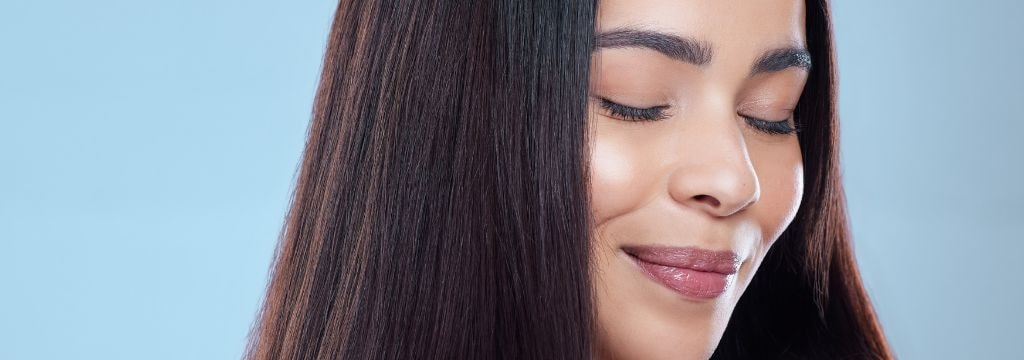 Jovem com o cabelo nutrido ao usar uma tinta de cabelo adequada com óleos nutritivos